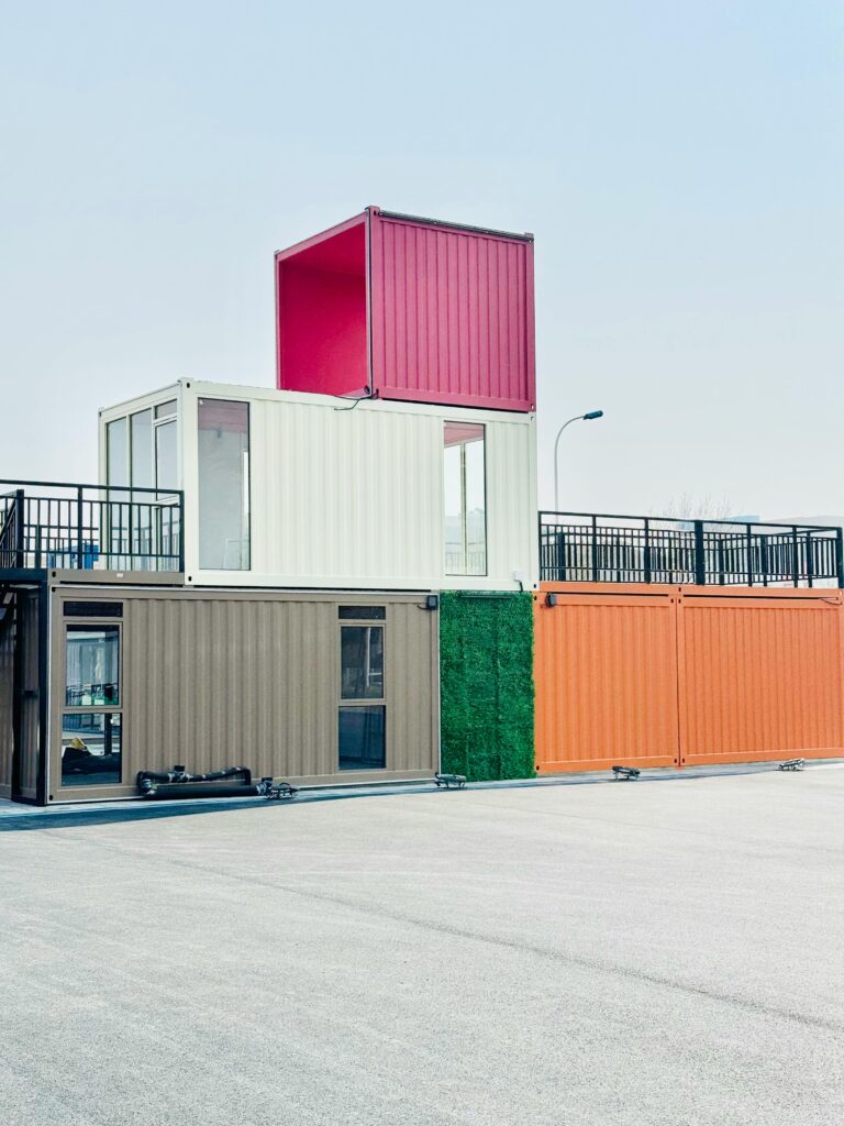 A modern container building featuring a vibrant, multicolored roof that adds a striking visual appeal to the structure